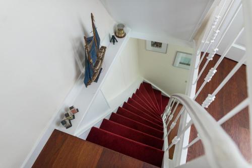 a staircase with a red carpet and a white stair case at Keizershouse Amsterdam in Amsterdam