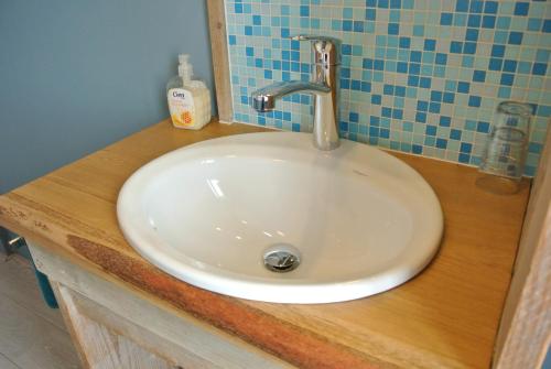 a white sink with a faucet on a wooden counter at Bed&Breakfast aan Strand in Katwijk aan Zee