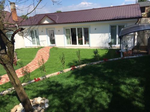 a house with a yard with green grass at Pension Julia in Banka
