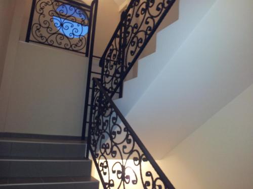 a staircase with a wrought iron railing with a stained glass window at Apartments Soleado in Pančevo