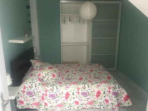 1 dormitorio con 1 cama con colcha de flores en Apartamento lima en Tamaduste