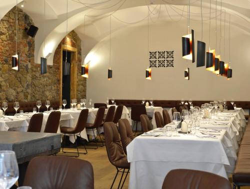 a dining room with white tables and chairs at Hotel Maribor, City apartments in Maribor