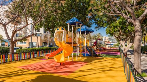a playground with a slide in a park at Aqua Apartments Vento, Marbella in Marbella
