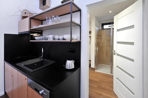 a kitchen with a sink and a black counter top at APLEND Vila Olívia in Smokovce