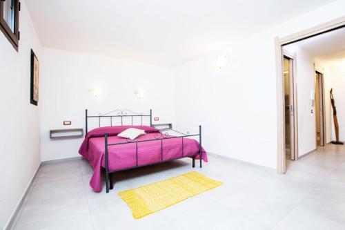 a bedroom with a pink bed and a yellow rug at Villino Enzo 350 mt Baia di Porto Frailis in Àrbatax