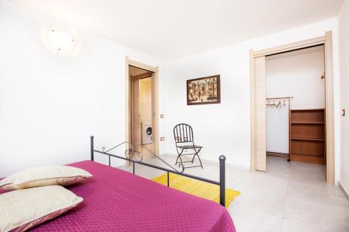 1 dormitorio con 1 cama de color púrpura y 1 silla en Villino Enzo 350 mt Baia di Porto Frailis en Àrbatax