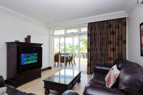 a living room with a leather couch and a table at Ballito Manor Gardens 303 - With Generator in Ballito