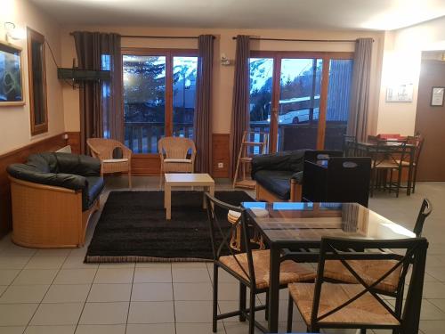 - un salon avec un canapé, une table et des chaises dans l'établissement Résidence Goélia Les Chalets de Super-Besse, à Super-Besse