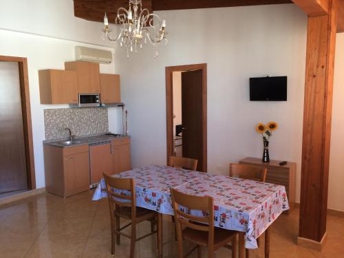 eine Küche und ein Esszimmer mit einem Tisch und Stühlen in der Unterkunft Hotel Aurora in Vieste
