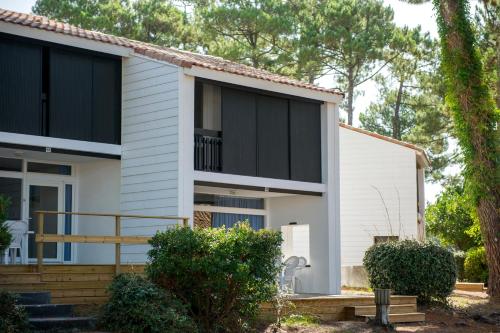 a white house with black windows at VTF La Jaougue Soule in Biscarrosse-Plage
