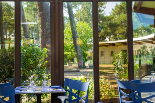 a table and chairs in front of a window at VTF La Jaougue Soule in Biscarrosse-Plage