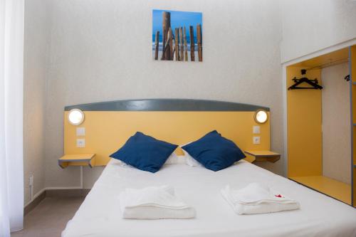 une chambre avec une tête de lit bleue et jaune dans l'établissement VTF La Jaougue Soule, à Biscarrosse-Plage