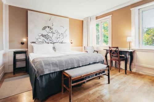 Schlafzimmer mit einem Bett, einem Tisch und einem Schreibtisch in der Unterkunft Stallmästaregården Hotel, Stockholm, a Member of Design Hotels in Stockholm