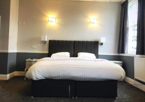 a bedroom with a large bed with two pillows at The Lion Hotel in Belper