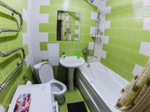 ペルミにあるApartments on Lenina 72Bの緑と白のバスルーム(トイレ、シンク付)