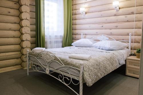 sypialnia z łóżkiem z drewnianą ścianą w obiekcie ApartHotel Pereslavskaya Sloboda w mieście Peresław Zaleski