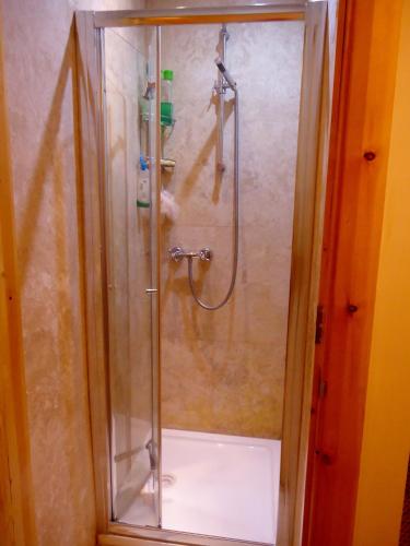 a shower with a glass door in a bathroom at Hour Glass Hotel in London