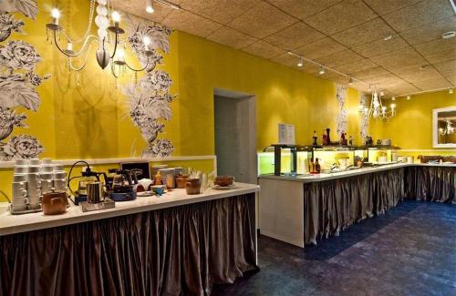 Un restaurante con paredes amarillas y mesas en una cocina. en Hotelli Seurahovi, en Porvoo