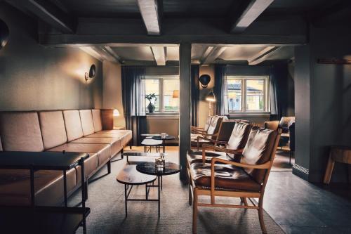 a living room with a couch and tables and chairs at Stallmästaregården Hotel & Restaurant, a Member of Design Hotels in Stockholm