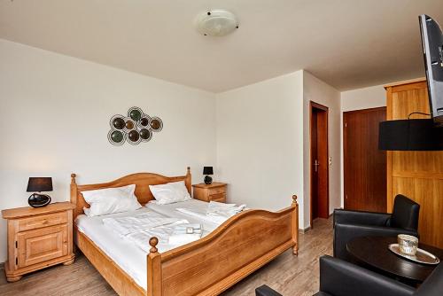 a bedroom with a bed and a chair and a television at Pension Haus am Einberg in Meschede