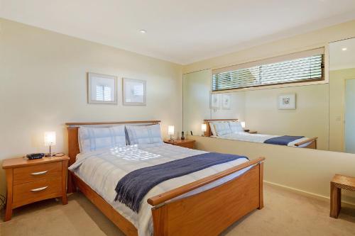 a bedroom with two beds and a window at Beach Breakers Apartment Stunning Views in Kianga