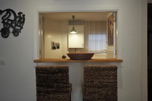 a kitchen with a counter with two wicker chairs at Bonito apart. con PARKING Y PISCINA in Mairena del Aljarafe