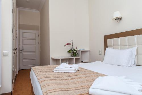 a bedroom with a large white bed with towels on it at 7 Sky on Yevhena Konovaltsia in Kyiv