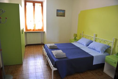 Un dormitorio con una cama azul con toallas. en Appartamento Al Ponte en Marone