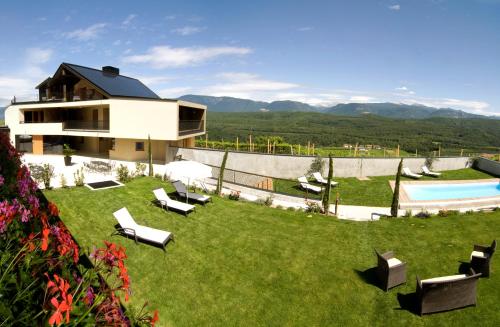 a house with a yard with chairs and a swimming pool at Biobauernhof St. Quirinus in Caldaro