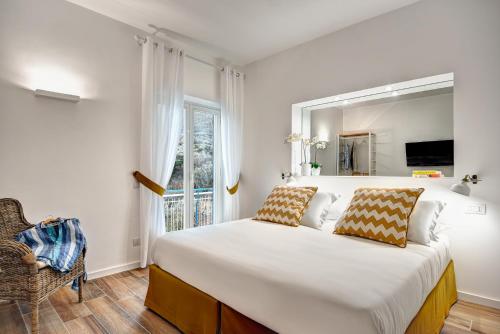 a white bedroom with a large bed and a window at Caruso 6 in Sorrento