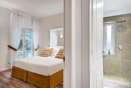 a white bedroom with a bed and a shower at Caruso 6 in Sorrento