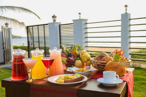 uma mesa coberta com pratos de comida e bebidas em Crystal Resort Dickwella em Dikwella