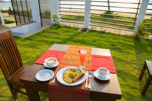uma mesa de madeira com um prato de comida sobre ela em Crystal Resort Dickwella em Dikwella