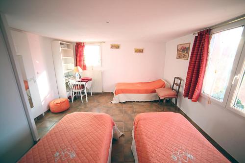 a small room with two beds and a table at B&B Le clos des vignes Saint Raphael in Saint-Raphaël