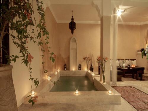 a bath tub in a room with lights at Riad Karmanda in Marrakesh