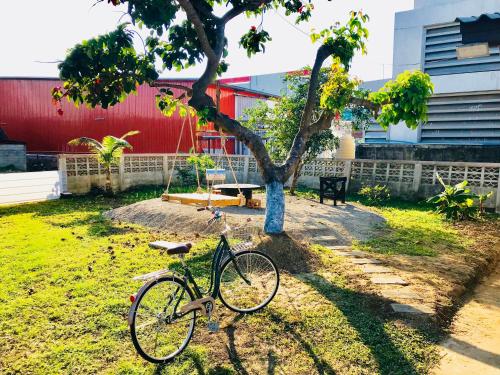 a bike parked next to a tree in a yard at Winter House Chiang Rai in Chiang Rai