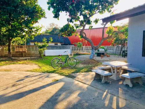 einem Picknicktisch und einem Fahrrad neben einem Gebäude in der Unterkunft Winter House Chiang Rai in Chiang Rai