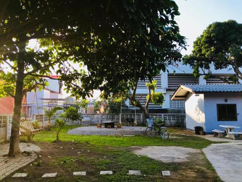 a park with a bike parked next to a building at Winter House Chiang Rai in Chiang Rai