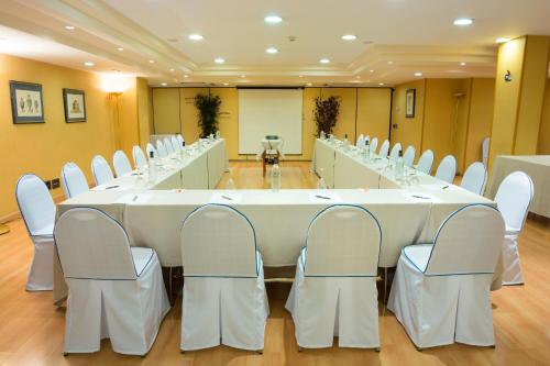 a conference room with a large white table and chairs at Hotel Gran Via in Logroño