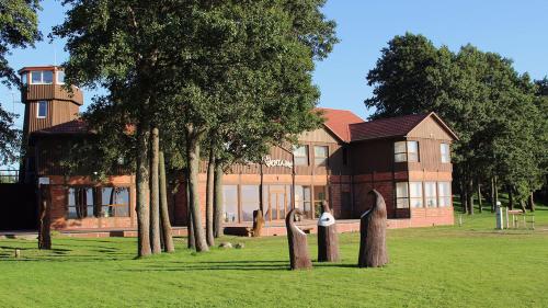 un gran edificio con árboles delante de él en Viešbutis Ventainė en Ventė
