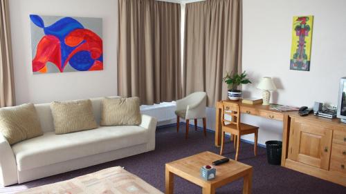 a living room with a couch and a desk at Viešbutis Ventainė in Ventė