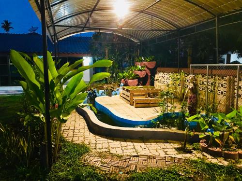 a garden with a patio with plants in it at Winter House Chiang Rai in Chiang Rai