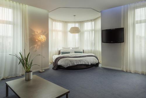1 dormitorio con 1 cama y TV. en Hotel Cubo en Liubliana