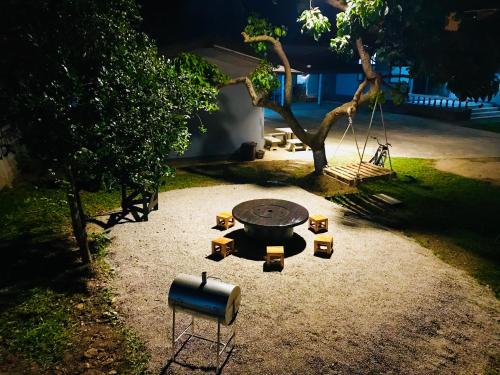 a barbecue grill in a yard with a tree at Winter House Chiang Rai in Chiang Rai