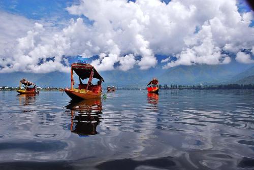drei Boote, die auf einem großen Wasserkörper schweben in der Unterkunft Shiraz Deluxe Houseboat in Srinagar