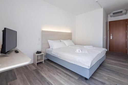 a bedroom with a bed and a flat screen tv at Hotel Internazionale Luino in Luino