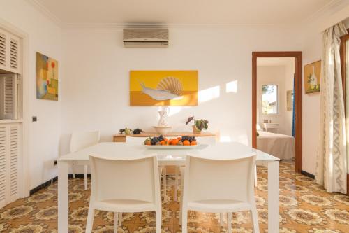 a dining room with a white table and chairs at Villa Cactus in Port d'Alcudia