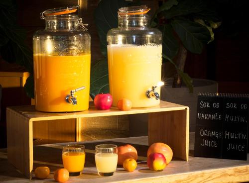 two jars of orange juice and apples on a wooden stand at Sun Gardens Dubrovnik in Dubrovnik