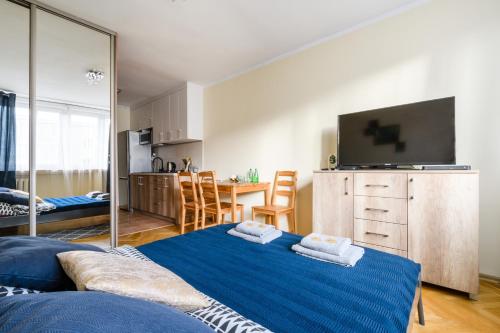 a living room with a blue bed and a kitchen at Premium Key-Apartaments Śródmieście in Warsaw