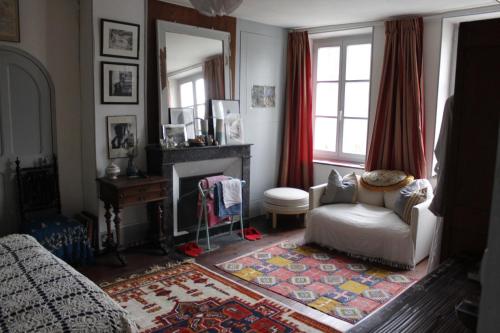 a living room with a chair and a fireplace at Avenue du Château in Saint-Just